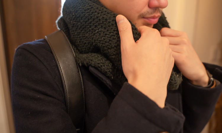 マフラーを外そうとする男性